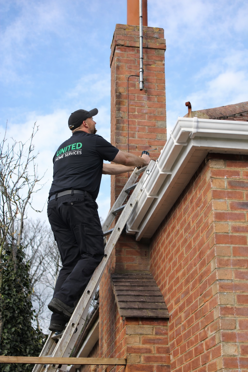technician inspecting chimney from ladder